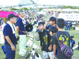 望遠鏡をのぞき込む参加者たち=6日、南ぬ浜町緑地公園