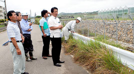 5日の記録的な大雨を受け、浸透池を視察する中山市長ら=7日午前、石垣市新川