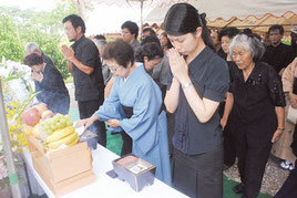 平和への願いを込めて手を合わせる全戦没者追悼式・平和祈念式の参列者=23日午後、八重守之塔前