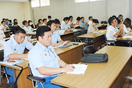 奥野氏の説明に聞き入る市職員ら=24日午後、市役所
