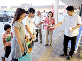 買い物客にティッシュを配り、行政相談会をPRする中山市長(右)ら=19日夕、イオンマックスバリュやいま店前