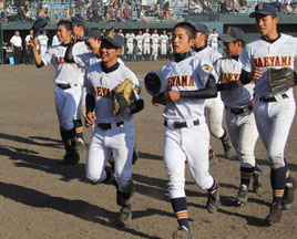 九州大会で初戦を突破し、ベンチに戻る八重高の選手ら=24日午後、鹿児島県