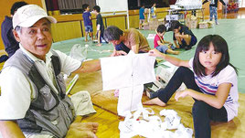 連凧作り教室の講師をつとめた富本衛さん(左)=23日、竹富小中学校体育館
