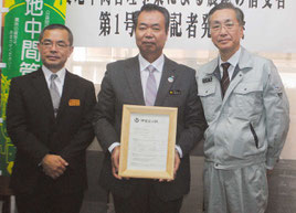 農地中間管理事業による第1号の賃借権設定を発表する川満町長(中央)、沖縄農業振興公社の比嘉理事長(右)ら=13日午後、町役場