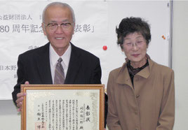 永年の野鳥保護活動が表彰され喜ぶ﨑山陽一郎さんと多津美夫人=19日午前