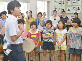 タンバリンを持ってルールを説明する平野教諭=20日、新川小学校