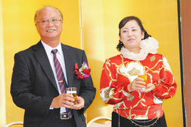 県漁連会長の就任祝賀会で、祝福に応え笑顔を見せる上原氏とりえ子夫人(26日夜)