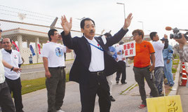 辺野古移設反対派に退去を呼び掛ける仲間氏(中央)=24日午後、名護市の米軍キャンプ・シュワブ前