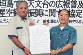 協定を結んだ市観光交流協会の高嶺良晴会長(左)と、代理の石垣島天文台の宮地竹史所長=27日午後、市観光交流協会事務局