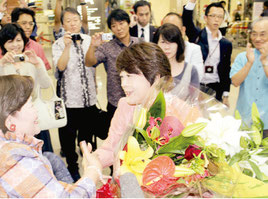 支援者らからの祝福の花束を受け取る島尻安伊子氏=10日午後、那覇空港国内線ターミナル