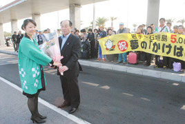 岩手・沖縄かけはし交流協会の福岡会長に花束が贈られた=23日午後、石垣空港