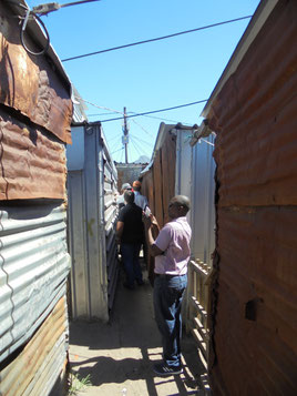 An image of the research team walking round the narrow routes of Masiphumelele informal settlement, Cape Town