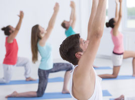Eine Gruppe von fünf Menschen macht Rücken-Yoga/Slow-Yoga. Bild Photographee.eu/Fotolia