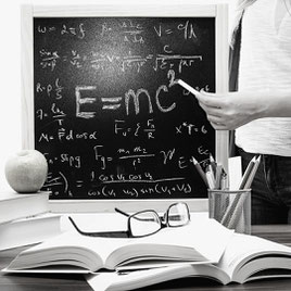 What is Einsteinian physics? A person holds a chalk in front of a blackboard