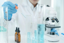 Mikroskop, Pipette, Glasflaschen, blaue Flüssigkeit