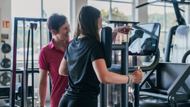 Trainerin unterstützt Mitglied an einem Trainingsgerät im GYM OHZ – persönliche Betreuung und individuelle Trainingsanpassung