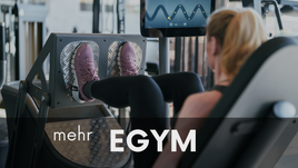 Frau trainiert an EGYM-Beinpresse mit digitalem Trainingsdisplay im Fitnessstudio Gym OHZ.