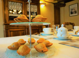 Panier de madeleines artisanales dorées servies sur la table du petit déjeuner à La Lysiane.