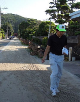 柏原海岸の砂で馬場を清めるお父さん