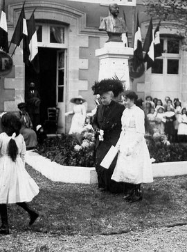 Mme Raymond venant de déposer des fleurs au pied du monument