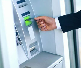 Hand führt Karte in Bankomat ein