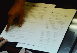 市民連絡会が署名用紙の実物(左の紙)を漢那副市長にみせた=14日、石垣市役所