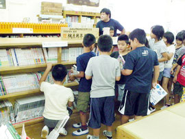貸し出しが始まった図書コーナーの前で競うように本を手にする児童たち=8日、同校図書室