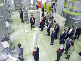 新製糖工場内を見学する関係者=28日午前、小浜