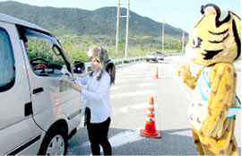 通行車両のドライバーへ安全運転を呼びかけた(10日、環境省西表野生生物保護センター提供)