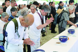 戦没者に手をあわせる参列者=23日、糸満市の県平和祈念公園