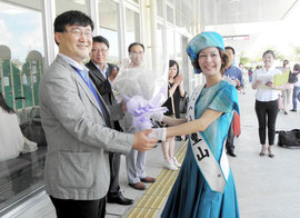 ミス八重山の古謝さんから花束を受けるチェ常務(左側)=石垣空港