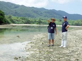 辻所長の案内で、川平湾に浮かぶ小島の周辺を視察した箕底議員(右)=13日午前、川平