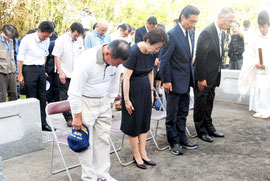 慰霊碑を前に拝礼する慰霊祭参列者=18日夕、石垣市新川