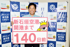 カウントダウン初日となる「開港まで140日」のボードを持つ中山市長。18日、フェイスブックに掲載された(市提供写真)