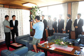 中山市長との会見後、一人ずつ記念撮影を求めて列を作る都議=25日午後、市役所