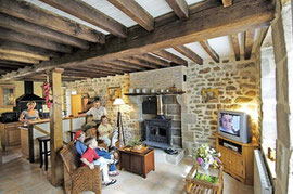 Gîte de Rameix, séjour - salon : pierres et boiseries, cheminée granit avec poêle, TV, Chaine HIFI, éclairage d'ambiance, atmosphère chaleureuse.