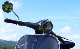 Vespa in front of white and blue sky