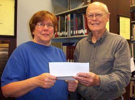Marla Vizdal, left, President of the McDonough County Genealogical Society, presents a donation to Louis Battin,President of the McDonough County Historical Society, to support the cemetery sign project of the MCHS