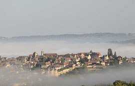 Domme dans la brume matinale