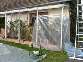 A plastic-sheeting shelter is being built 