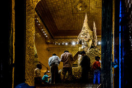Das Mahamuni-Buddha-Bild: Der Tempel ist dem Mahamuni-Buddha-Bild gewidmet (Bedeutung etwa 'Der grosse Weise'). Es wird als Ausdruck der Darstellung des Lebens von Buddha angesehen und wird daher in Burma sehr verehrt.
