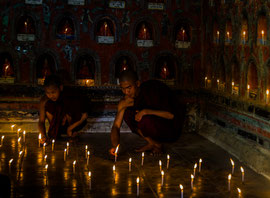 Novizen beim Entzünden von Kerzen im Shwe-Yan-Pyay-Kloster: das Entzünden steht für die Entfaltung des inneren Lichts und den Weg zu Weisheit und Erleuchtung.