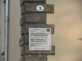 Hausnummer und Hinweis auf den Zugang auf der Gebäuderückseite