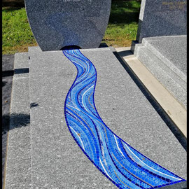 Monument funéraire contemporain en granit orné d'une rivière sinueuse réalisée en mosaïque artisanale dans des nuances de bleu et or Orsoni