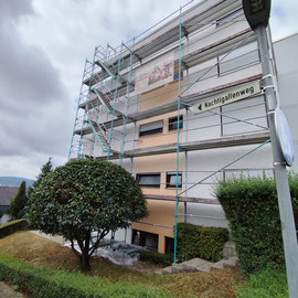 Fassade mit Wasserschaden und Grafitti, bereits mit Gerüst aufgestellt.