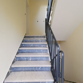 Treppenhauswände mit einem hoch belastbaren Putz neu modelliert und neu lackiertem Geländer 