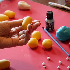 1. Teile dir dein gelbes Fondant ein, je nachdem wie groß du die Minions haben möchtest. Rolle das gelbe Fondant zu kleinen Kugeln und dann zu kleinen Eiern (Geht eher in Richtung Ü-Ei-Form). 