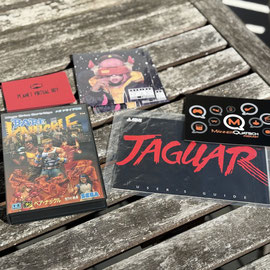 Das Bild zu Männerquatsch Podcast Folge 190 zeigt Einkäufe von der Retrobörse Oberhausen im Mai 2025 u.a. Bare Knuckle 1 für Mega Drive, Jaguar Anleitung und das Tronimal Album Robonaut auf CD.