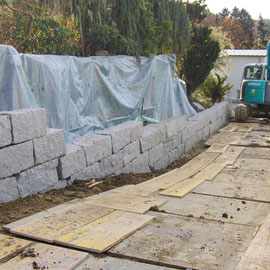 Während dem Bau einer Granitsteinmauer mit Blocksteinen, auf dem nächsten Foto ist die gesamte Mauer ersichtlich.