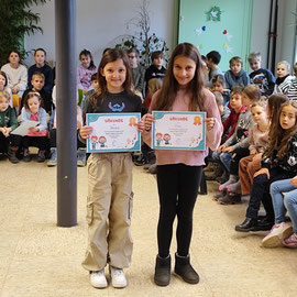 Die zwei Mädchen aus der Schildkrötenklasse halten ihre Urkunden in der Hand